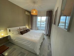 ein Schlafzimmer mit einem Bett und einem großen Fenster in der Unterkunft Cozy apartment in Costa del Sol in Mijas Costa
