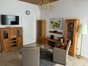 ein Wohnzimmer mit einem TV, einem Tisch und Stühlen in der Unterkunft Gästehaus Mietz in Bad Neuenahr-Ahrweiler