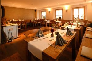 a restaurant with wooden tables and chairs and tablesearcher at Bernhardhof Andechs in Andechs