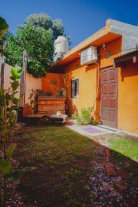 una casa amarilla con una puerta y un patio en La Escondida en Córdoba