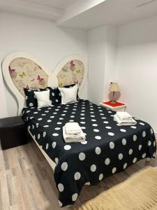 1 dormitorio con cama de lunares blanca y negra en Vikings Grigo Apartaments, en Cluj-Napoca