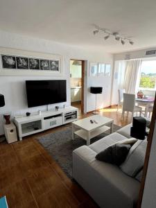 a living room with a couch and a flat screen tv at Soleares Apartment - Close to the Beach! in Estepona