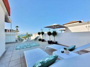 a patio with white tables and chairs on a roof at Attic 10 by Grupo Compostelana in Puerto de la Cruz