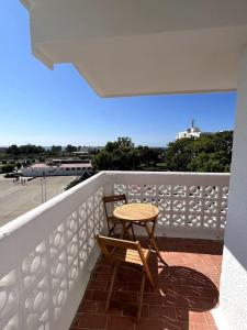 a wooden table and chair on a balcony at Soleares Apartment - Close to the Beach! in Estepona +24 photos