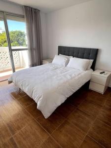 a bedroom with a large white bed with a window at Soleares Apartment - Close to the Beach! in Estepona