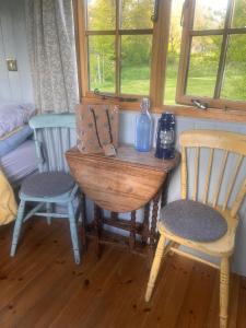 エムズワースにあるSindles Farmの椅子2脚、テーブル(ボトル1本付)が備わる客室です。