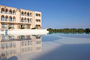 a building with its reflection in a body of water at Cora Hotel & Spa in Afitos