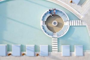 Cora Hotel & Spa في أفيتوس: درج حلزوني في مسبح عليه ناس