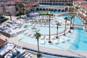 einen Luftblick auf einen Pool mit Palmen des Resorts in der Unterkunft Cora Hotel & Spa in Afytos