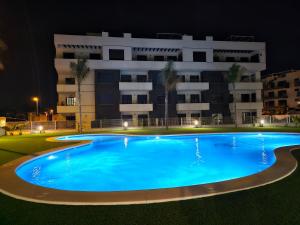 una piscina frente a un edificio por la noche en VillaMartin Casa hermano, en Villamartin