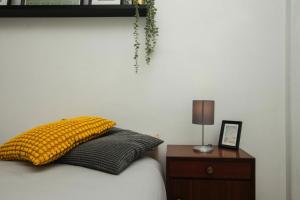 a bedroom with a bed with a yellow pillow and a nightstand at Low Cost Subway Privado in Lisbon