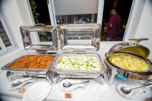 een tafel met drie dienbladen eten erop bij San Marino Hotel in Accra