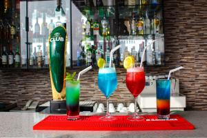 een groep van vier verschillende gekleurde dranken op een bar bij San Marino Hotel in Accra