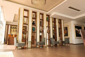 a room with chairs and a wall of shelves at San Marino Hotel in Accra