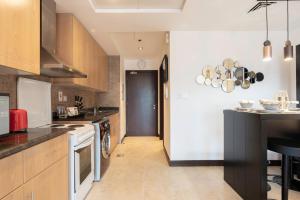 a kitchen with wooden cabinets and a black counter top at GuestReady - Lux Studio with a View in Dubai