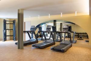 a gym with a row of treadmills and ellipticals at Cora Hotel & Spa in Afitos