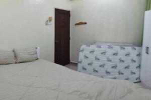 une chambre avec un lit blanc et un réfrigérateur dans l'établissement Kim Kim Homestay Melaka(11 Pax 4R2B), à Malacca