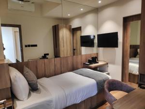 um quarto de hotel com uma cama e um espelho em Maxxvalue Hotel MIDC - Andheri em Mumbai