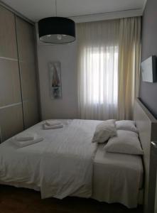 a bedroom with a white bed with towels on it at Athens Acropolis cozy apartment in Athens