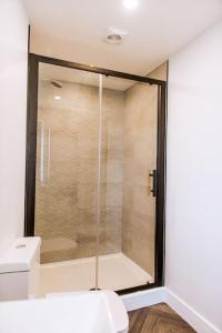 a glass shower in a bathroom with a toilet at Superior 1 Bed Studio 1D near Royal Infirmary & DMU in Leicester