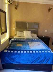 a bed in a bedroom with a blue comforter at Villa 141 in Sheikh Zayed