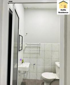 a bathroom with a toilet and a sink at NoWa Residence in Mersing