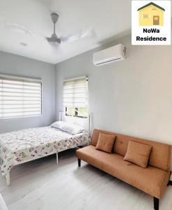 - une chambre avec un lit et un canapé dans l'établissement NoWa Residence Rumah Kuning, à Mersing