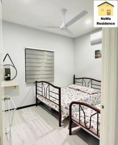 a bedroom with two beds and a ceiling fan at NoWa Residence Rumah Kuning in Mersing