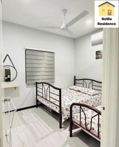 um quarto com 2 camas e uma ventoinha de tecto em NoWa Residence Rumah Kuning em Mersing