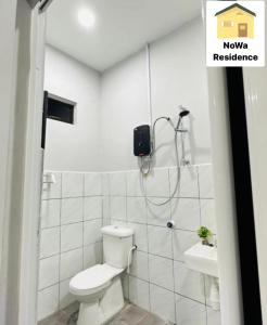 a white bathroom with a toilet and a sink at NoWa Residence in Mersing