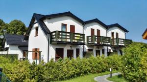 a white house with a black roof at 11 Maków in Mielenko