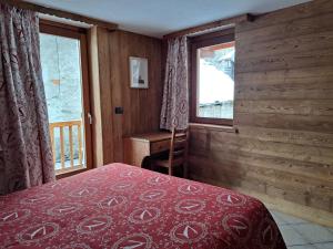 a bedroom with a bed and a window at L'Abreny in Brusson