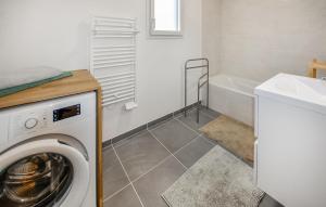 a washing machine in a bathroom with a sink and a tub at Nice Home In Le Pontet With Kitchen in Avignon