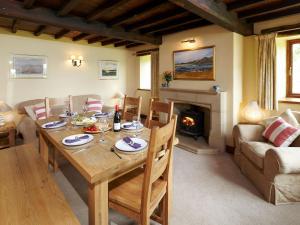 une salle à manger avec une table et une cheminée dans l'établissement The Farmhouse - Uk4188, à Hazlehead Bridge