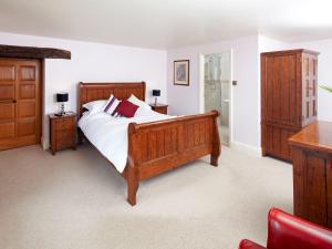 a bedroom with a large bed with wooden furniture at The Farmhouse - Uk4188 in Hazlehead Bridge