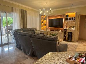 een woonkamer met een bank en een televisie bij Villa Esmeralda Residencial Cocotal Bavaro in Punta Cana