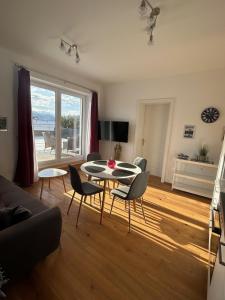 ein Wohnzimmer mit Tisch und Stühlen in der Unterkunft CityLake G23 Apartments mit kostenlosem Parkgaragen-Stellplatz !! in Gmunden