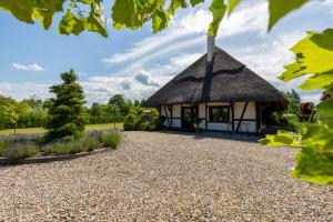 a thatch roofed building with a gravel driveway at mussurhouse in Ustka
