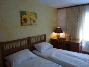 sypialnia z 2 łóżkami i biurkiem z lampką w obiekcie Landgasthof Faymann 