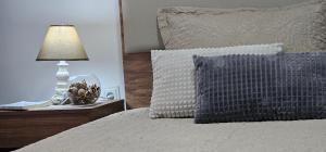 a bed with a pillow and a lamp on a night stand at Superb 1 bedroom in the best zone of the city. in Ferizaj