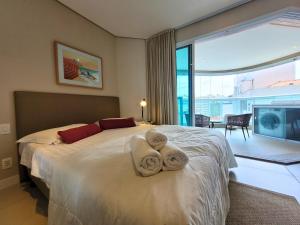 a bedroom with a large bed with towels on it at Book Santos - Estanconfor 1201 - Conforto e comodidade na quadra da Praia in Santos