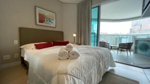 a hotel room with a bed with towels on it at Book Santos - Estanconfor 1201 - Conforto e comodidade na quadra da Praia in Santos