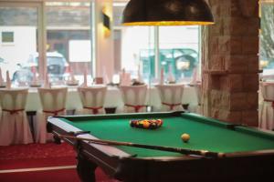 una mesa de billar en una habitación con una mesa con sillas en AaRa Hotel en Radeberg