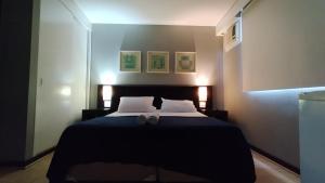 a bedroom with a bed with two slippers on it at M-Flat II Hotel - Vila Olimpia in Sao Paulo +12 photos