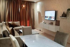 a living room with a couch and a tv at Prestigia Jade Marrakech in Marrakesh