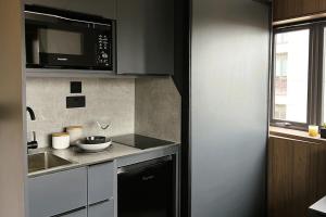 uma cozinha com um lavatório e um micro-ondas em Deluxe 1 Bed Studio 4C near Royal Infirmary & DMU em Leicester
