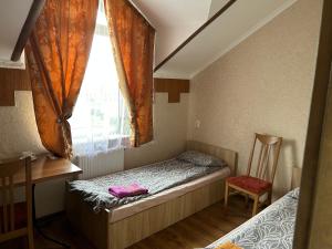 Habitación pequeña con cama y ventana en Готель Максим en Drogovyzhe