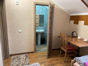 Habitación con baño con lavabo y mesa. en Готель Максим en Drogovyzhe