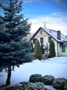 un bâtiment avec un panneau aapo sur son côté dans la neige dans l'établissement Pensjonat Rondo, à Września
