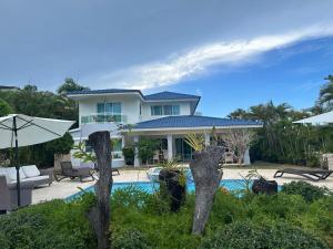 een huis met een zwembad ervoor bij Villa Esmeralda Residencial Cocotal Bavaro in Punta Cana